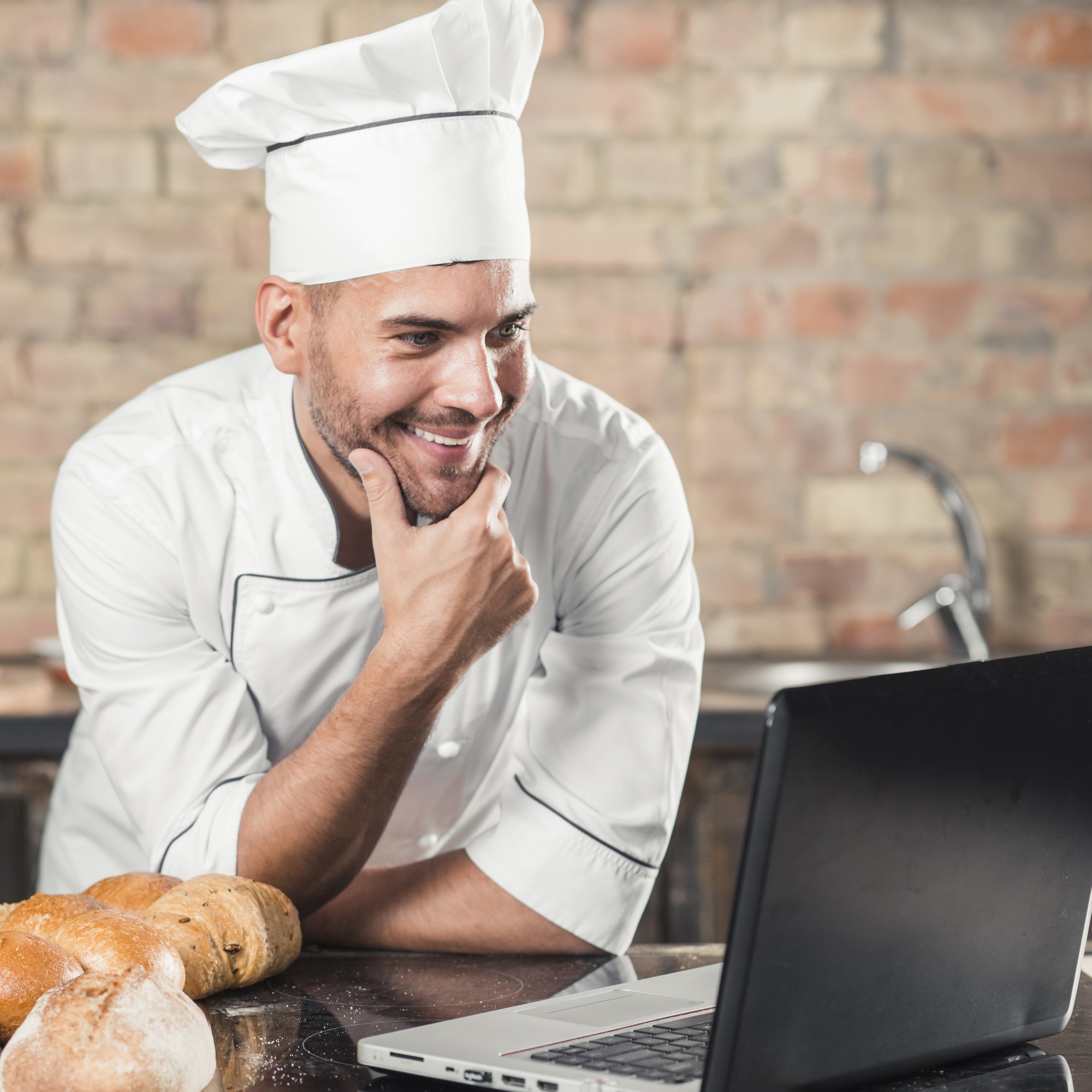 Chef che sorride vicino a banco di lavoro